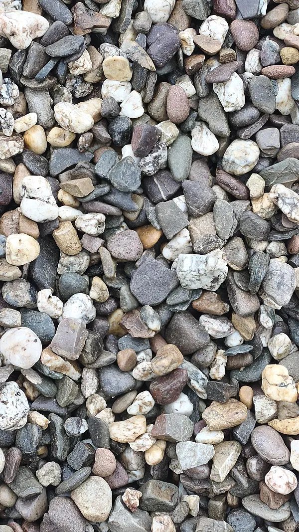 Eine Ansammlung verschiedenfarbiger Drainagekies-Steine in Nahaufnahme.