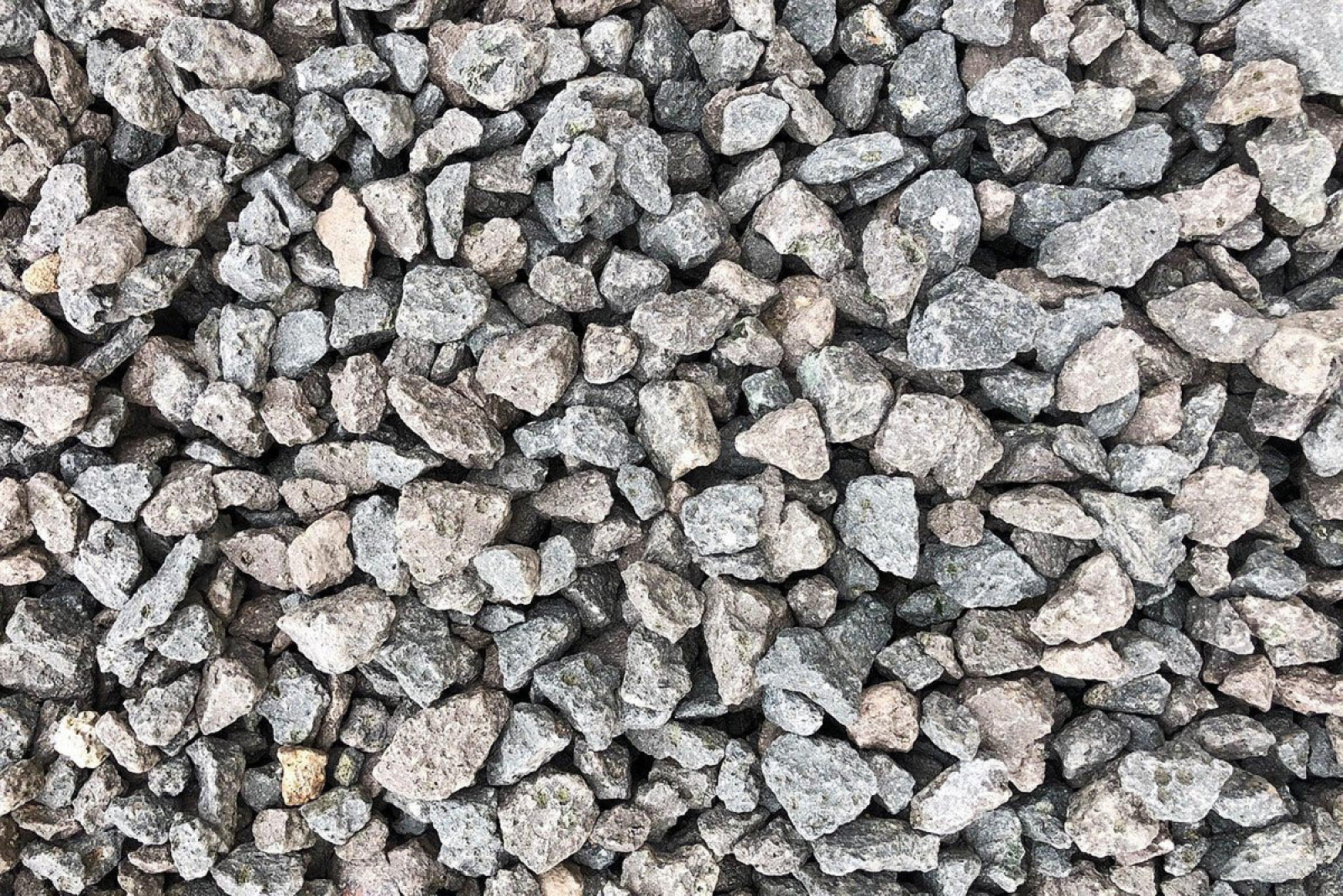 Runde, graue und braune Drainagekies-Steine in unterschiedlichen Größen, gleichmäßig verteilt.