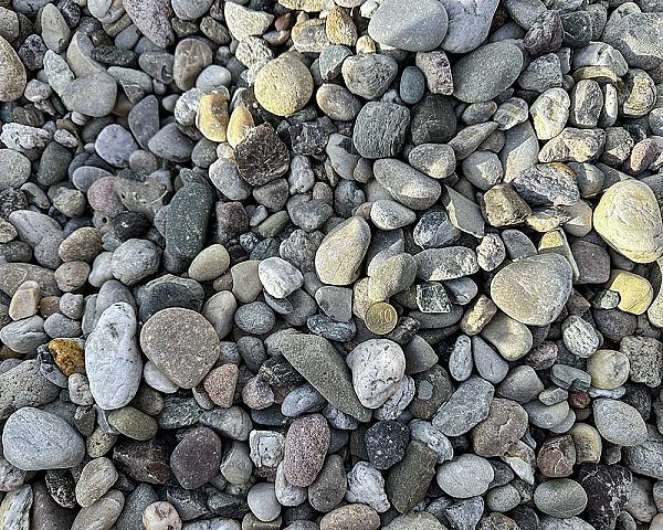 Drainagekies von Hünten GmbH, Nahaufnahme von verschiedenfarbigen, glatten Steinen.