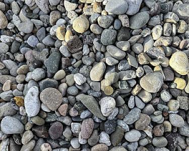 Drainagekies von Hünten GmbH, Nahaufnahme von verschiedenfarbigen, glatten Steinen.