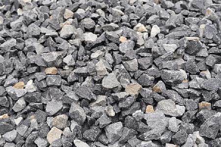 Grauer Basaltsplitt in verschiedenen Größen auf einer Fläche verstreut. Markenname: Hünten GmbH.