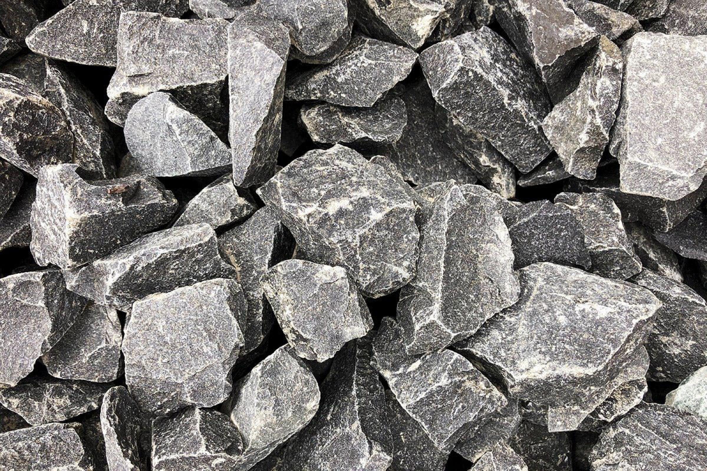 Basaltsplitt von Hünten GmbH in verschiedenen Größen und Formen, grob und grau, für Bau-, Garten- und Landschaftsprojekte.