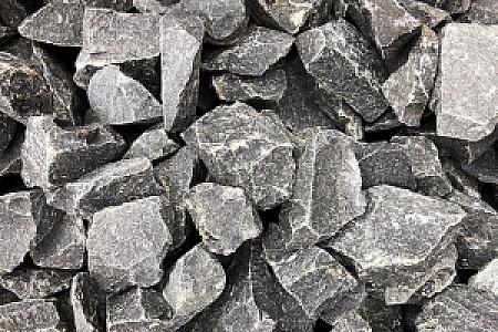 Basaltsplitt von Hünten GmbH in verschiedenen Größen und Formen, grob und grau, für Bau-, Garten- und Landschaftsprojekte.