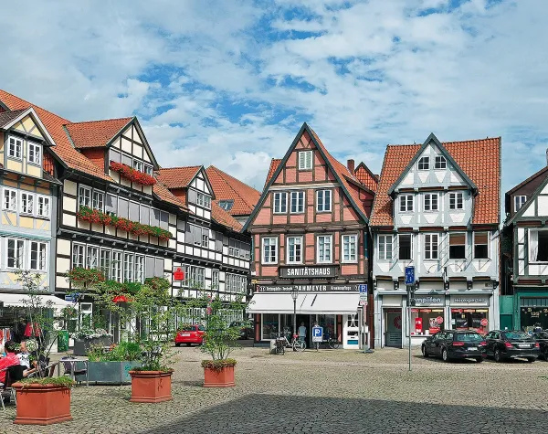 Historische Fachwerkhäuser am Marktplatz in Celle bei bewölktem Himmel.