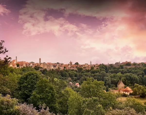 Stadtansicht von Rotenburg (Wümme) mit historischer Architektur und bewaldeter Landschaft bei Sonnenuntergang.