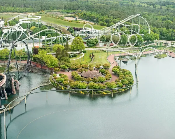 Freizeitpark mit Achterbahnen, Wasser und begrünter Insel im Heidekreis, Deutschland.