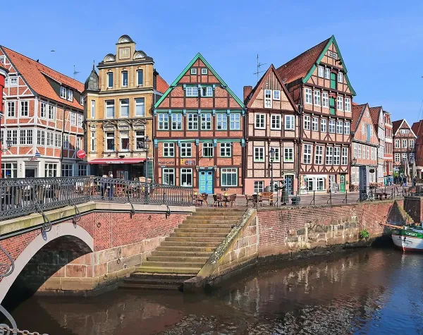 Historische Fachwerkhäuser am Wasser in Stade bei sonnigem Wetter.