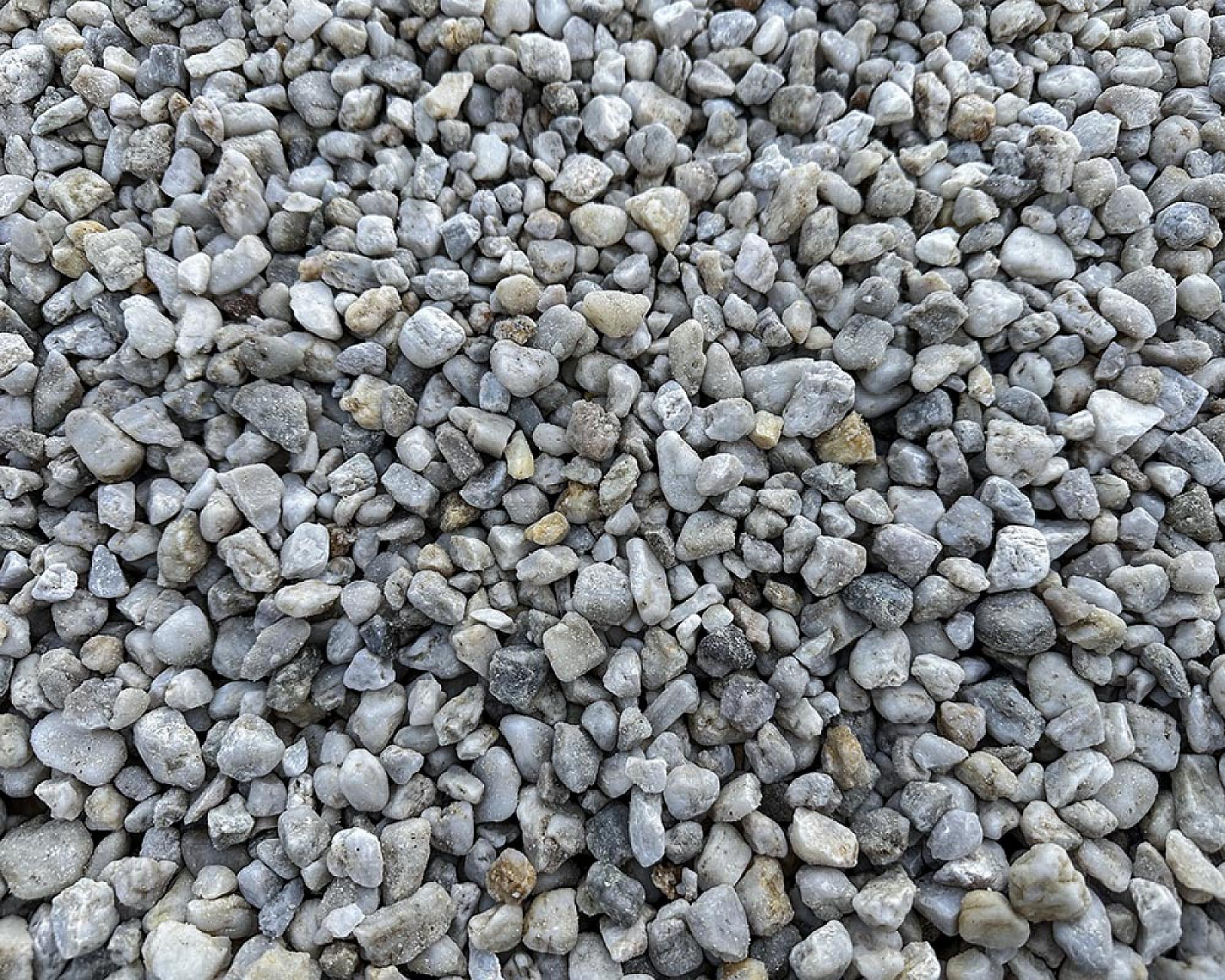 Weiße Quarzkiesel in verschiedenen Größen, Nahaufnahme. Produkte der Marke Hellerwald.