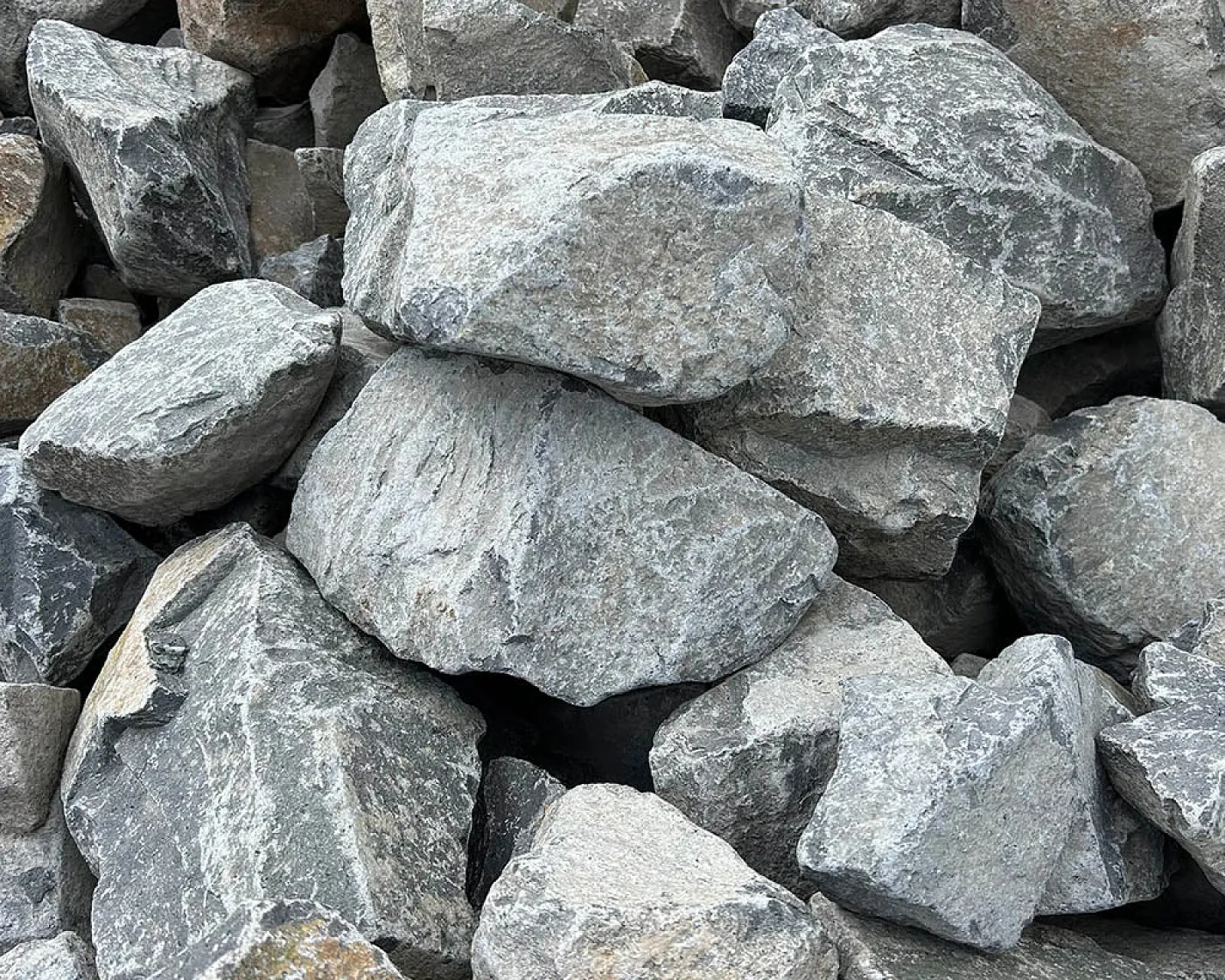 Graue, grobe Basaltsteine, unregelmäßig geformt, liegen auf einem Haufen.