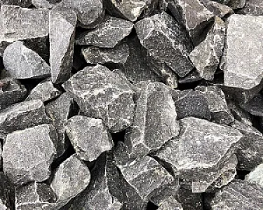 Graue Basaltsplitt-Steine in verschiedenen Größen und Formen, eng angeordnet.