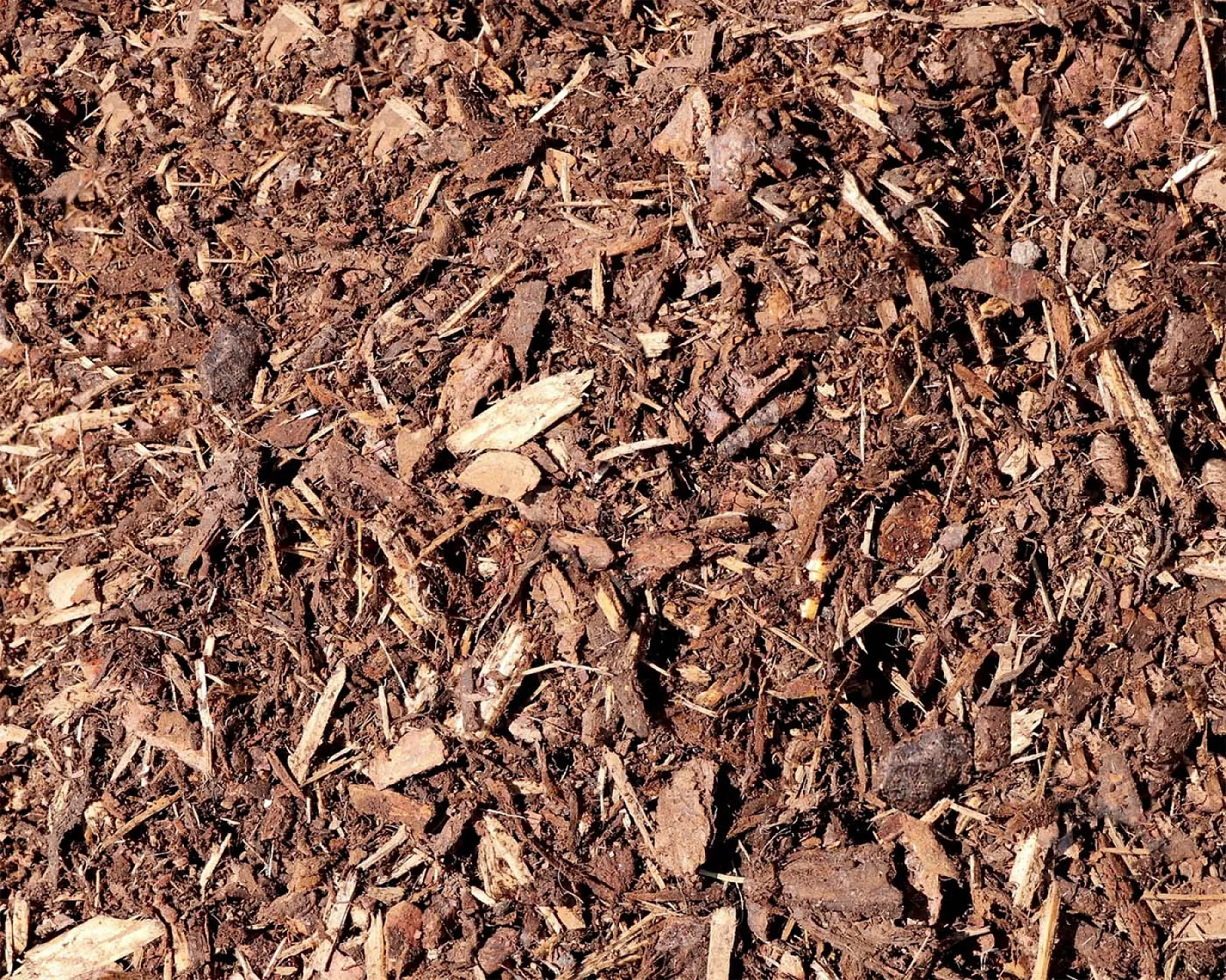 Fein gehackter brauner Rindenmulch, gleichmäßig verteilt, von der Marke Hellerwald.