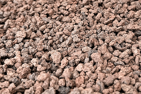 Lavaschotter auf einem Haufen, verwendet für Garten- und Landschaftsbau, braune und graue Gesteinsbrocken.