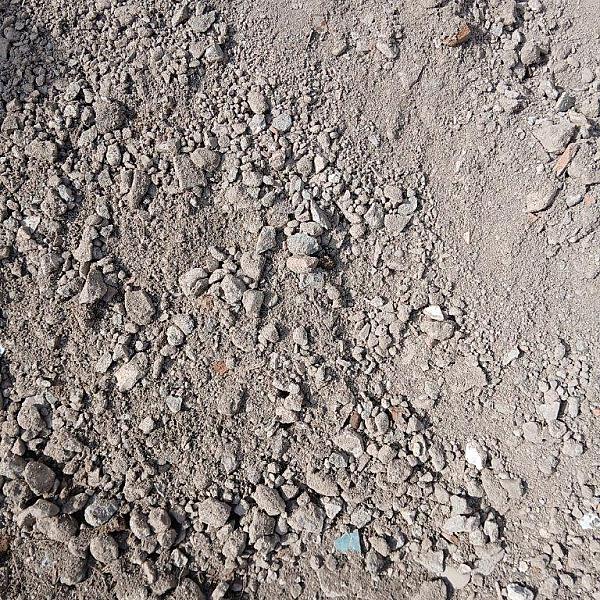 RC-Recyclingschotter aufgestapelt, grau, uneben, mit verschieden großen Steinen und Staub. Florikomp Erden & Substrate GmbH.