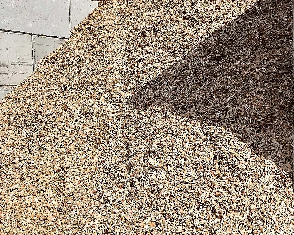Holzhackschnitzel lose aufgestapelt, natürliche Holzspäne auf dem Boden.
