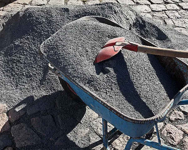 Schubkarre mit grauem Basaltsplitt 2-5mm von Florikomp, daneben Haufen auf Pflastersteinen.