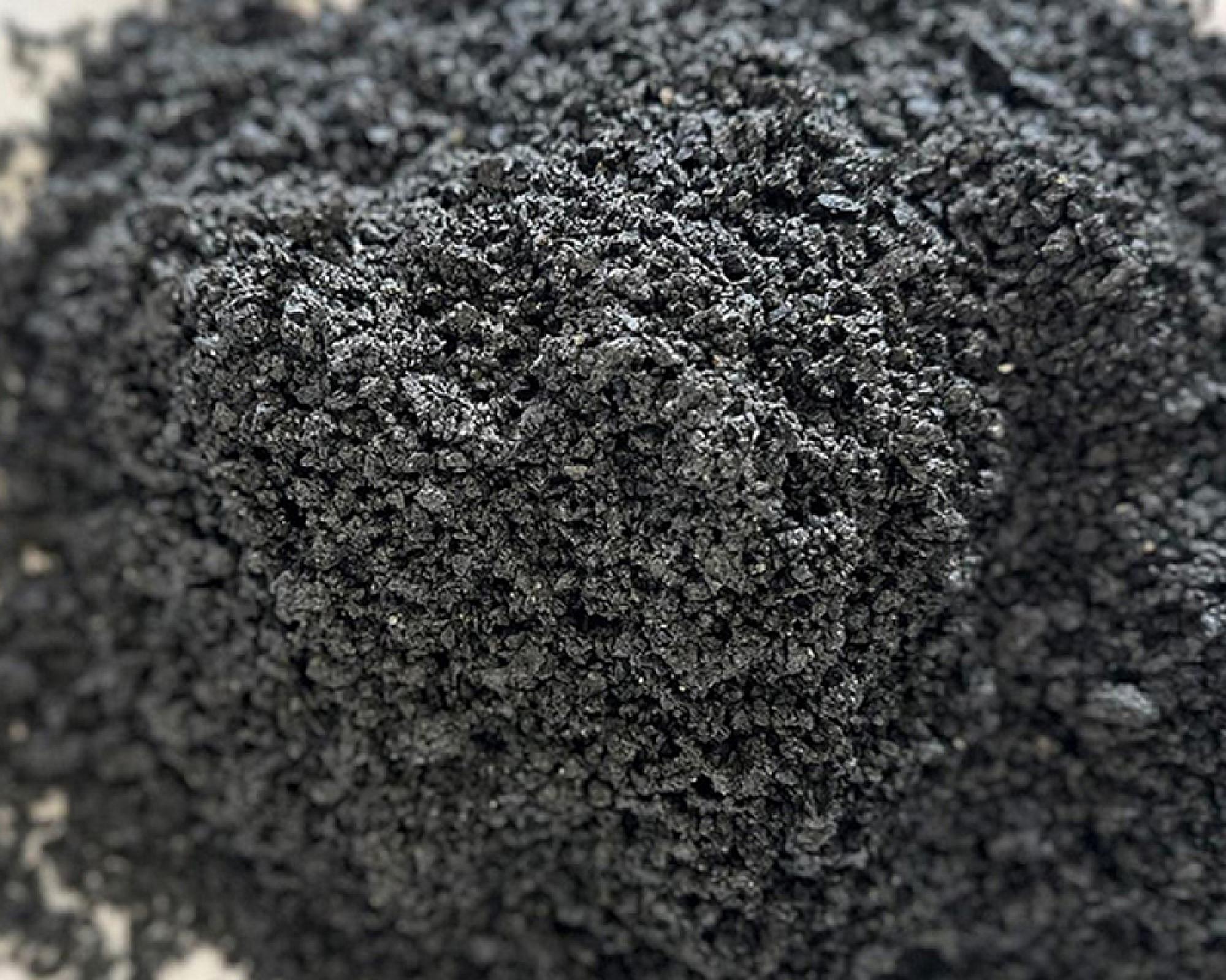 Dunkler, feinkörniger Basaltsand in Nahaufnahme, Markenprodukt von Volz und Herbert GmbH.