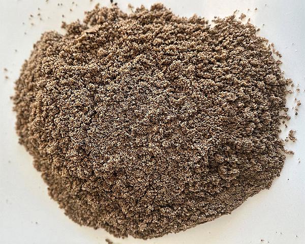 Ein Haufen feiner Rohrsand auf einer hellen Oberfläche, bereit für die Verwendung in Bauprojekten.