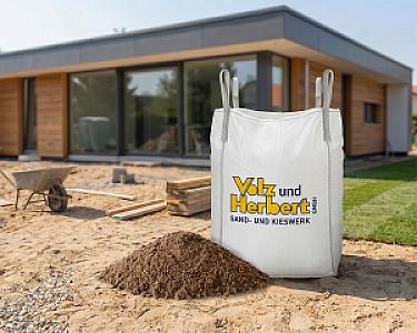Großer weißer Big Bag mit Sand vor modernem Haus, Beschriftung: Volz und Herbert GmbH.