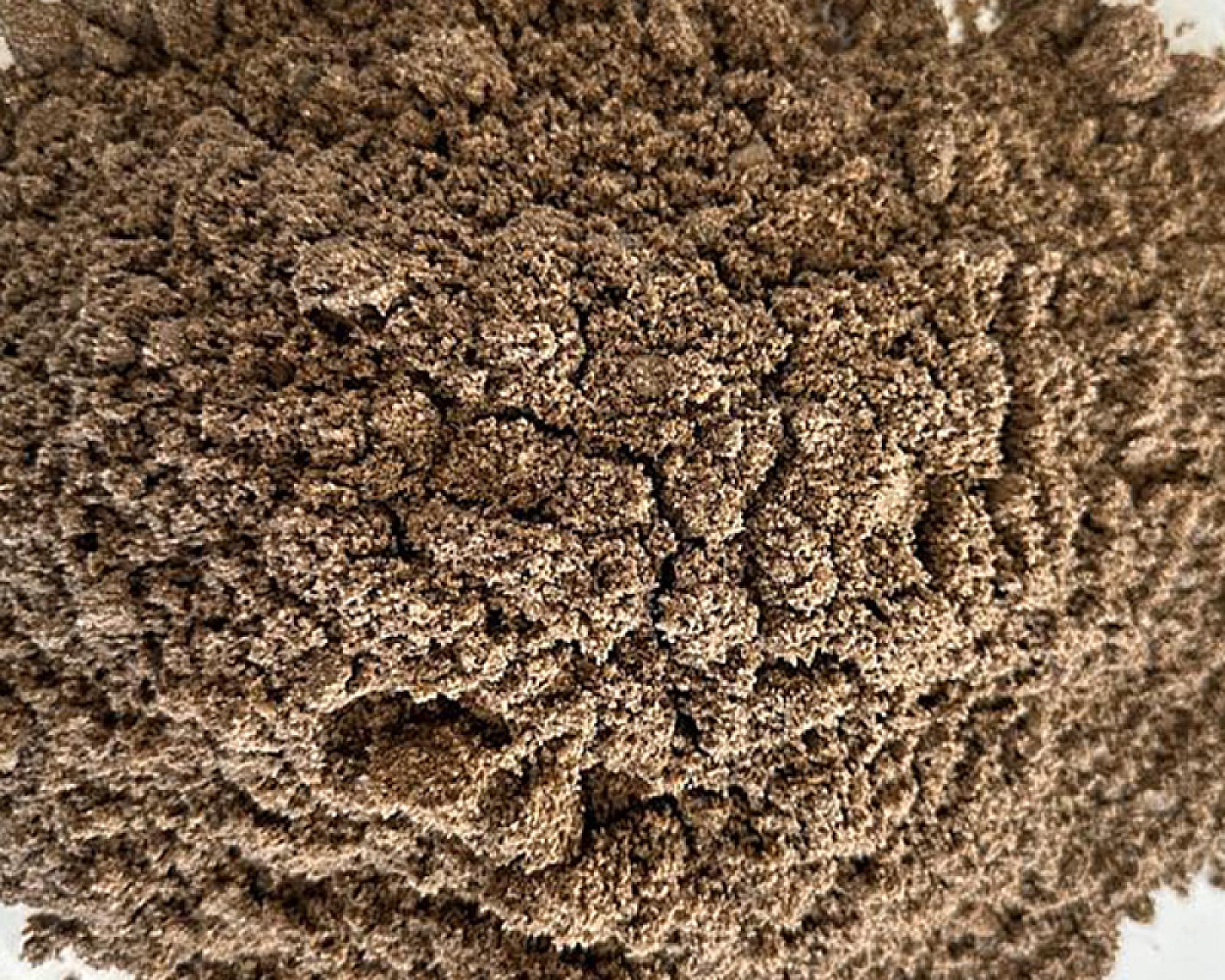 Recyclingsand der Marke Volz und Herbert, grobkörnige Konsistenz, natürliche Erdtöne.
