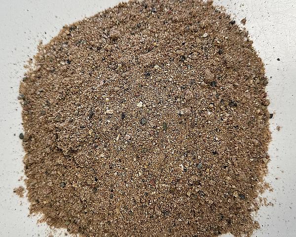 Häufung von sandfarbenem, gewaschenem Sand mit feinkörniger Struktur auf weißem Hintergrund.