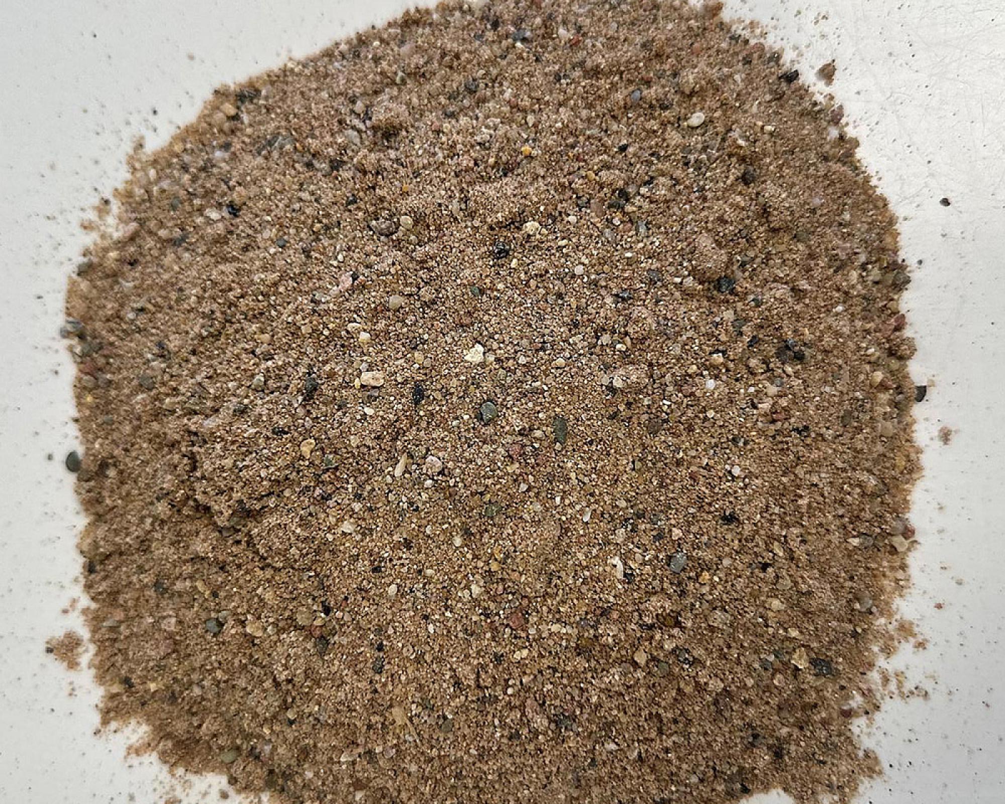 Ein Haufen beige bis grauer gewaschener Sand von Volz und Herbert GmbH.