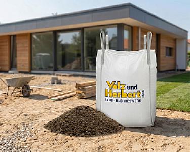Großer weißer Bausand-Container von Volz und Herbert GmbH auf Baustelle vor modernem Gebäude.