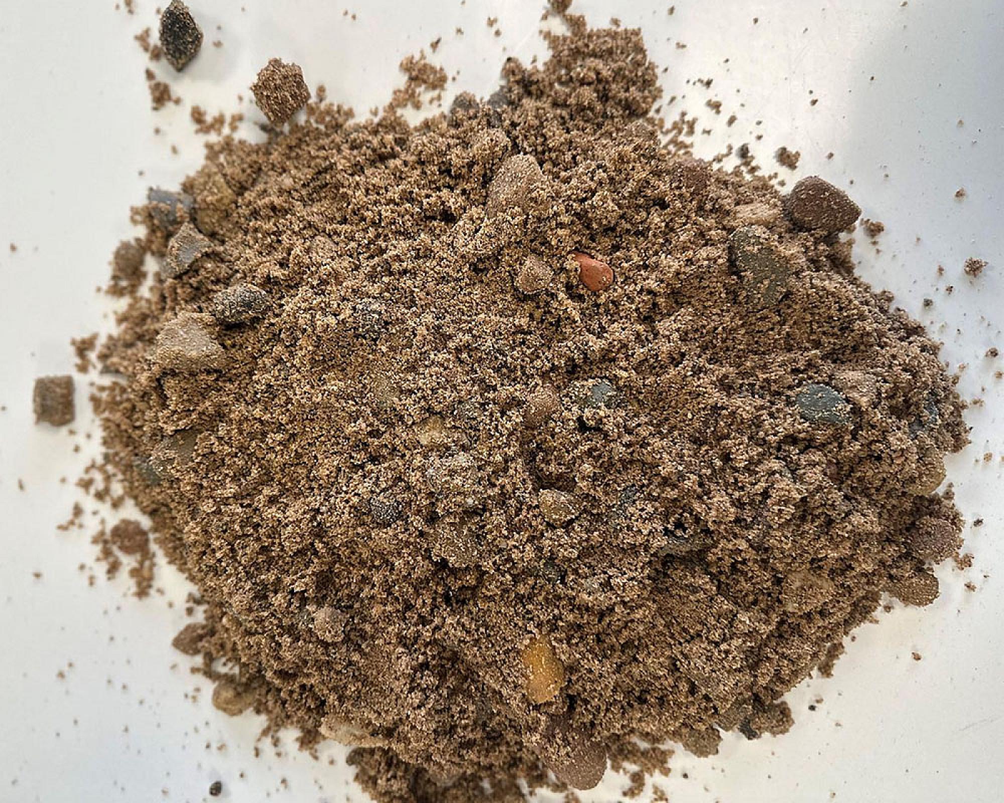 Haufen Betonkies auf weißem Hintergrund, Mischung aus Sand, Kieselsteinen und feinen Partikeln.