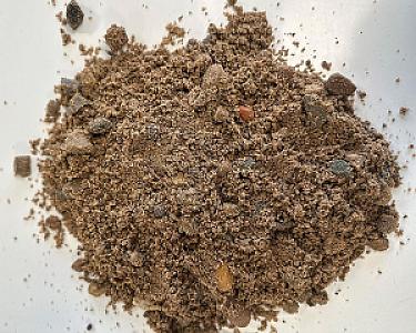 Haufen Betonkies auf weißem Hintergrund, Mischung aus Sand, Kieselsteinen und feinen Partikeln.