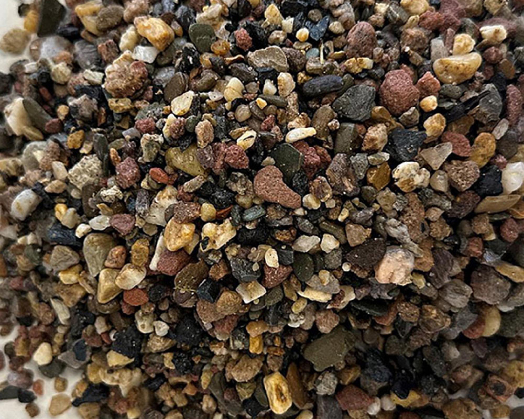 Nahaufnahme von gemischtem Fallschutzkies in unterschiedlichen Farben und Größen.
