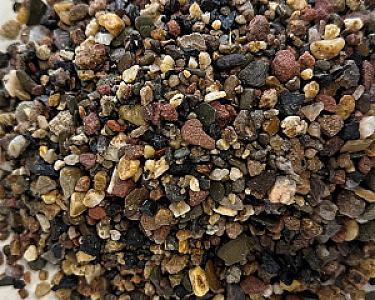 Nahaufnahme von gemischtem Fallschutzkies in unterschiedlichen Farben und Größen.