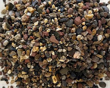 Haufen von gemischtem Filterkies in verschiedenen Naturfarben, geeignet für Filtration.