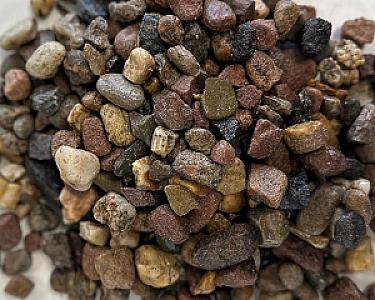 Bunte Mischung aus unterschiedlich großen Filterkieseln auf einem Haufen.