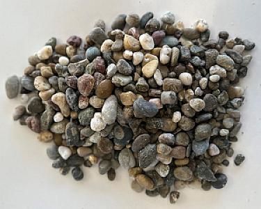 Verschiedene bunte Rheinkies-Steine, gewaschen, auf weißem Untergrund.