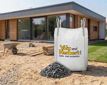 Großer Big-Bag mit Basaltsplitt 8-16 mm von Volz und Herbert GmbH, vor einem modernen Haus auf einer Baustelle.