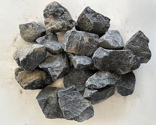 Basaltsplitt 8-16 mm auf hellem Hintergrund, dargestellt als Schüttgut der Marke Volz und Herbert GmbH.