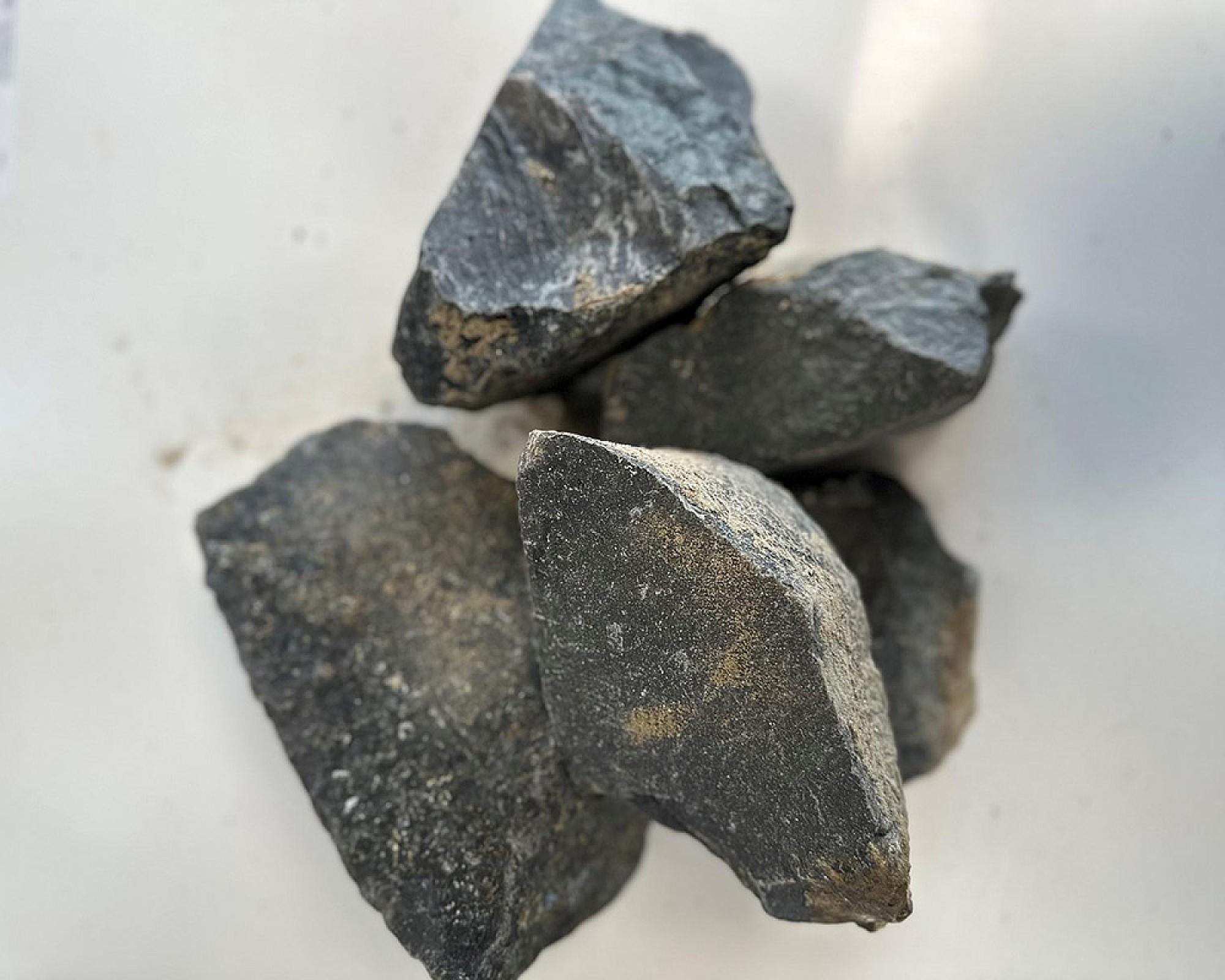 Basaltsplitt 8-16 mm, dunkle Steine auf hellem Hintergrund, von Volz und Herbert GmbH.