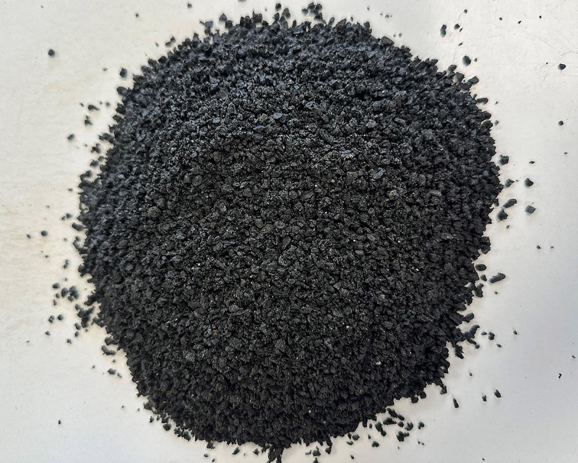 Fugensplitt der Marke Volz und Herbert GmbH, grobkörniges schwarzes Material, auf heller Oberfläche.