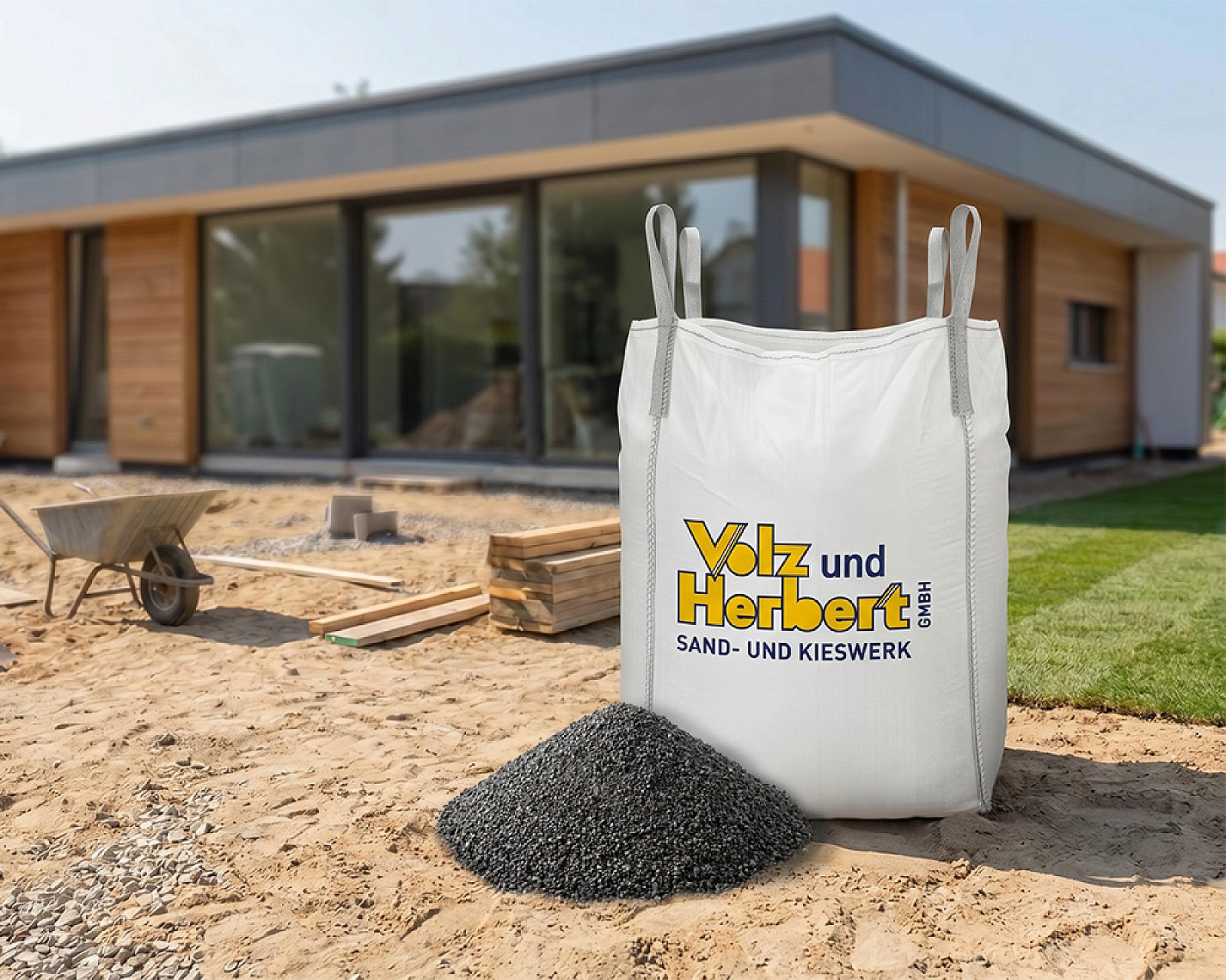 BigBag mit Fugensplitt der Marke Volz und Herbert auf Baustelle vor modernem Haus.