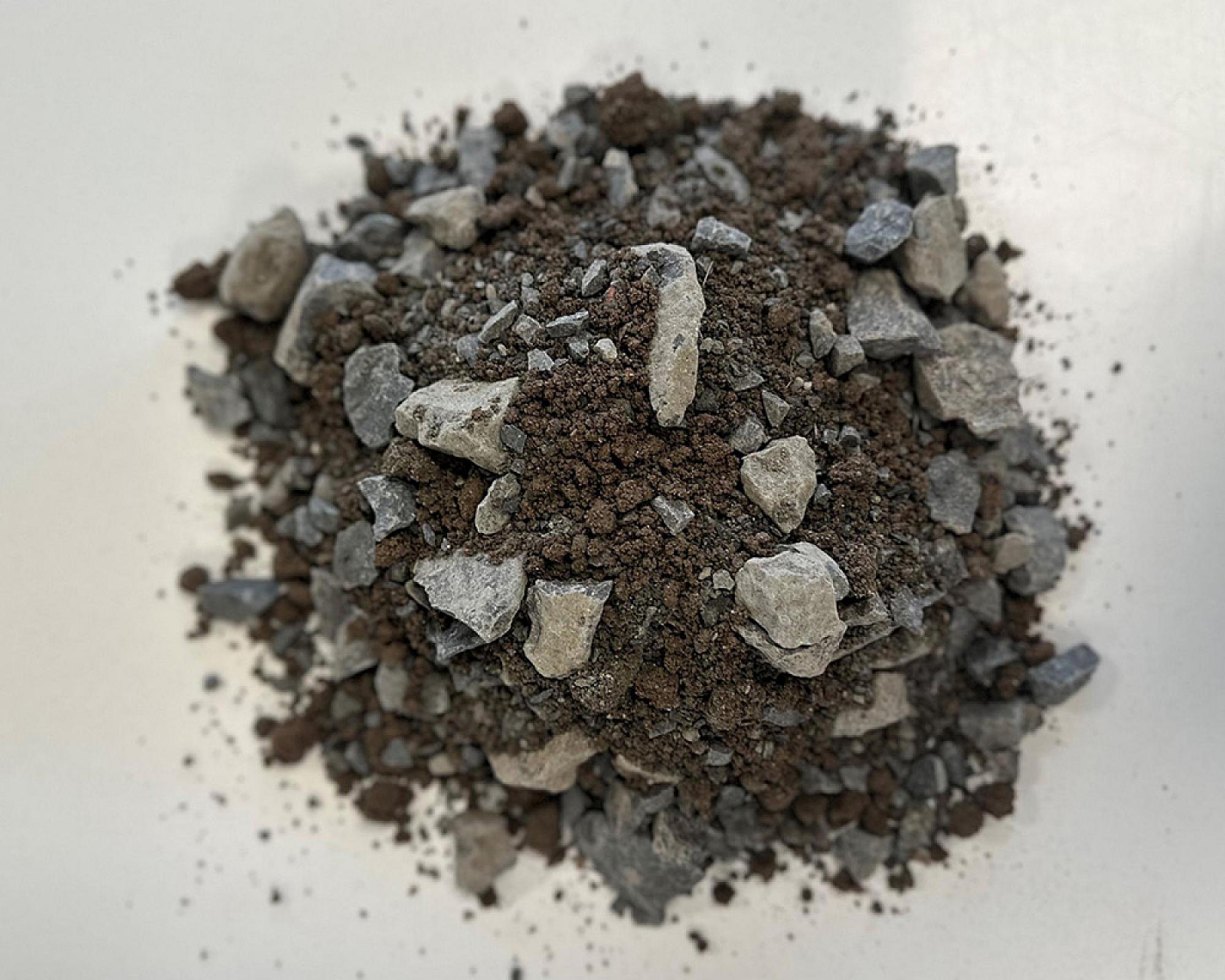 Haufwerk aus Erde und Steinen auf weißem Hintergrund, Bestandteil der Vegetationstragschicht.
