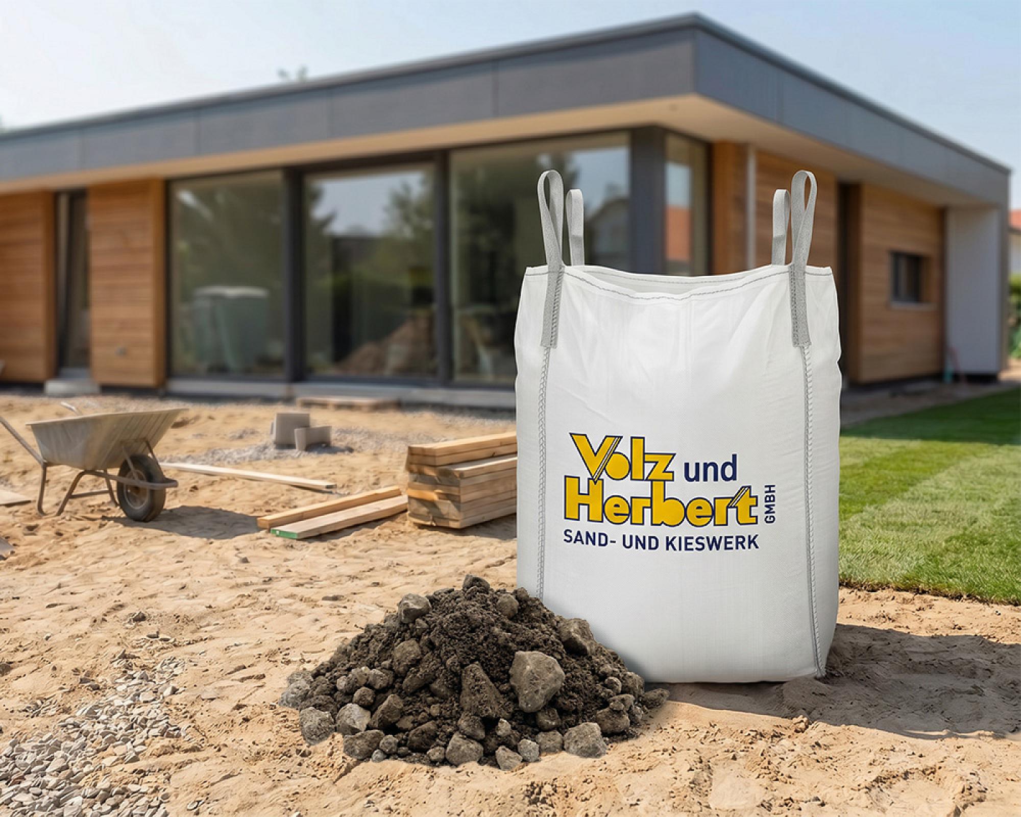 BigBag mit RC-Betonschotter der Volz und Herbert GmbH auf einer Baustelle vor einem Haus.