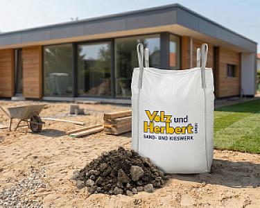 BigBag mit RC-Betonschotter der Volz und Herbert GmbH auf einer Baustelle vor einem Haus.