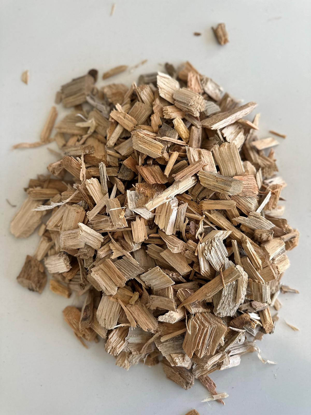 Haufen aus Holz-Hackschnitzeln von Volz und Herbert GmbH auf hellem Hintergrund.