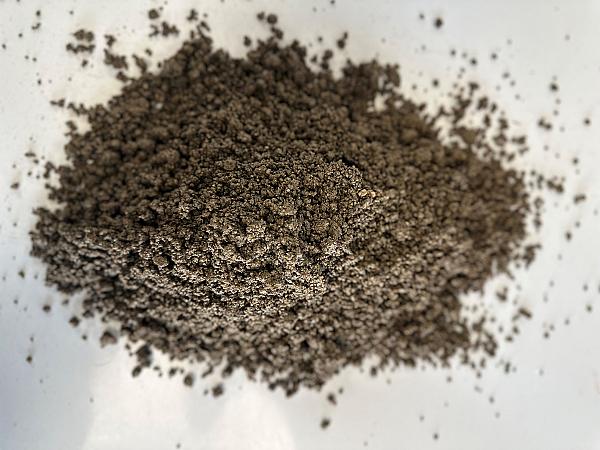Ein Haufen naturfarbener Felsenkies auf weißem Hintergrund.