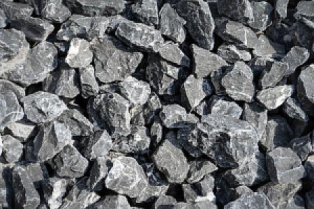 Belgischer Blaustein: grobe, kantige Steinfragmente in dunklem Grau, gestapelt für Bau- oder Gestaltungsprojekte.