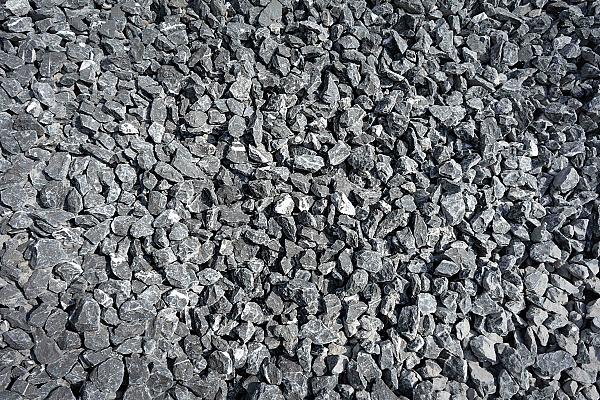 Haufen aus groben, grauen belgischen Blaustein-Kieseln.
