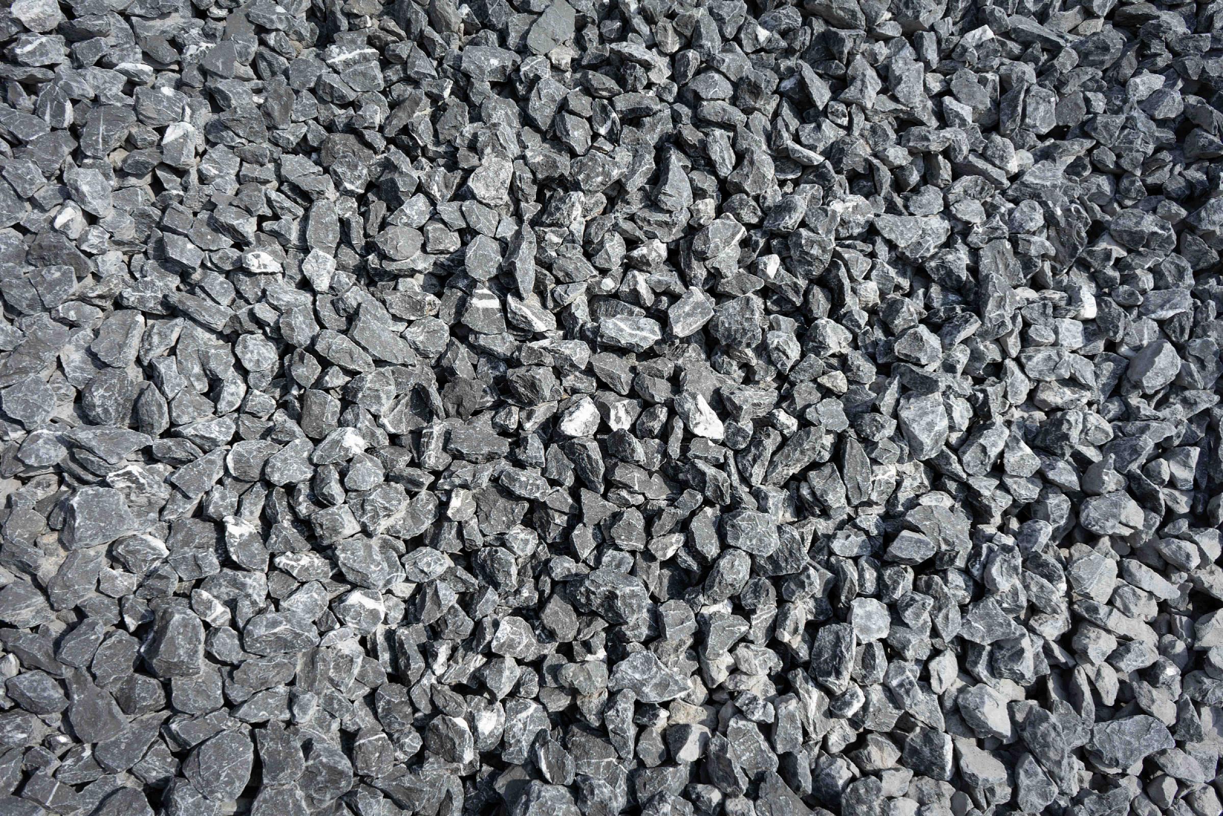 Haufen aus groben, grauen belgischen Blaustein-Kieseln.