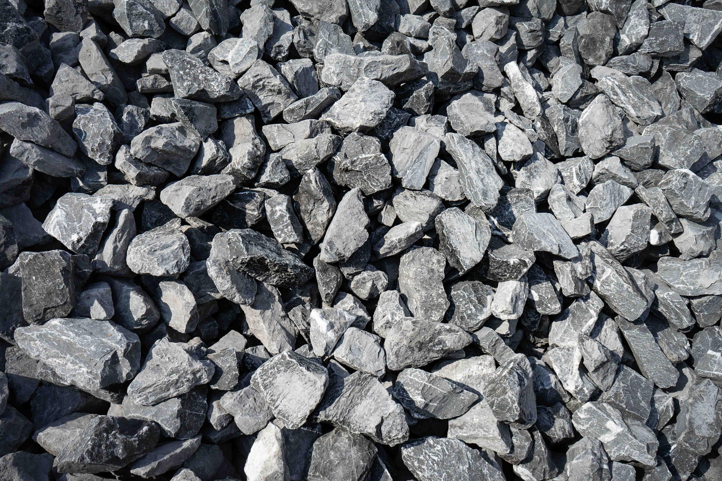 Stapel grober belgischer Blaustein-Steine von HTA GmbH für Bauarbeiten.