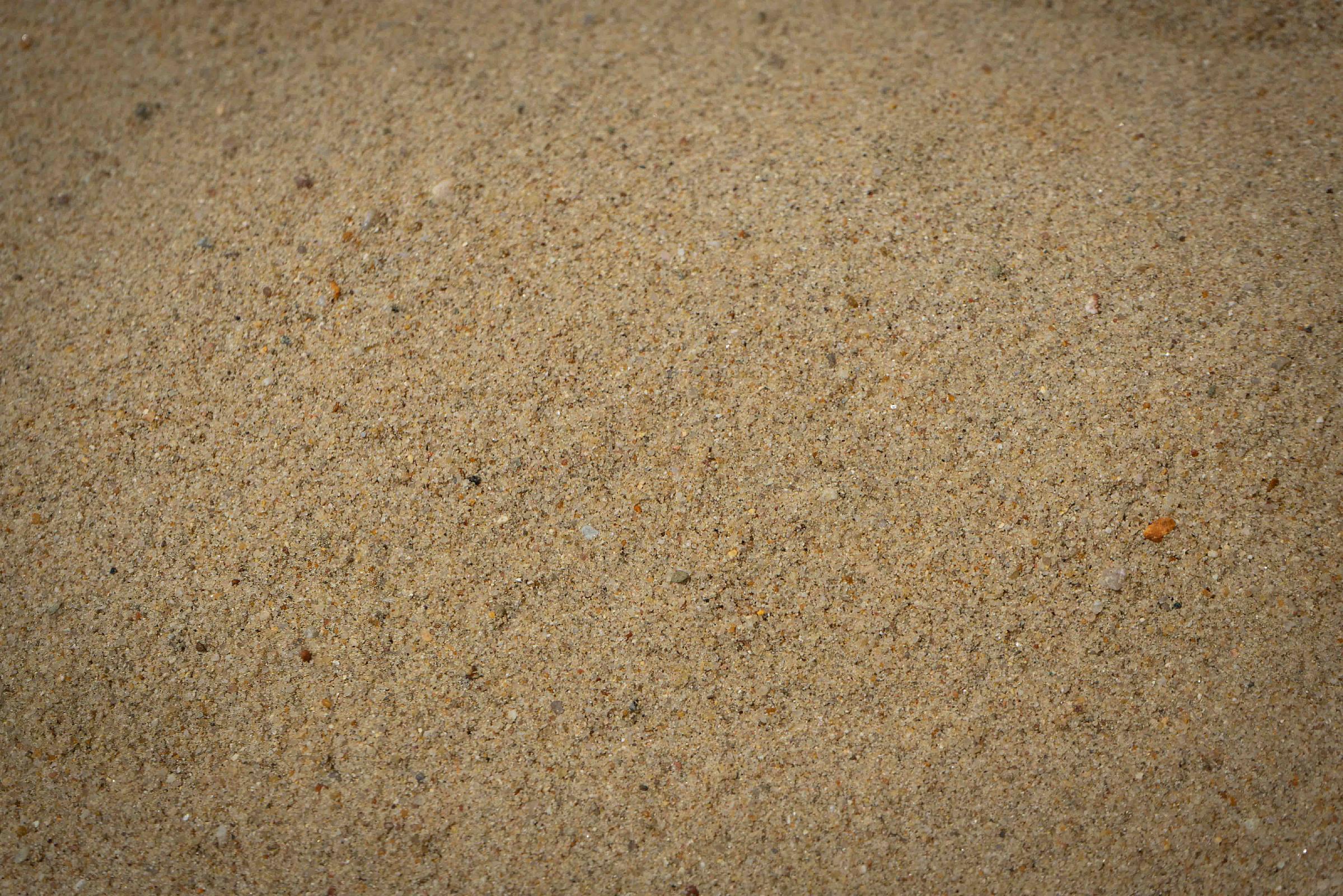 Nahaufnahme von gewaschenem Sand der Marke HTA GmbH, gleichmäßig verteilt.