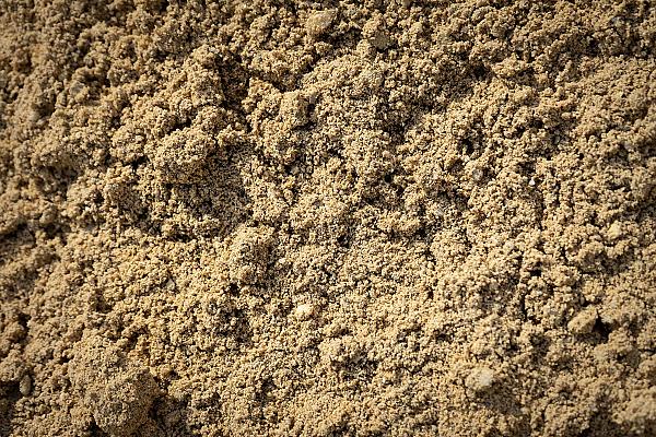 Nahaufnahme von gewaschenem Sand der HTA GmbH aufgeschüttet, beige und grobkörnig.
