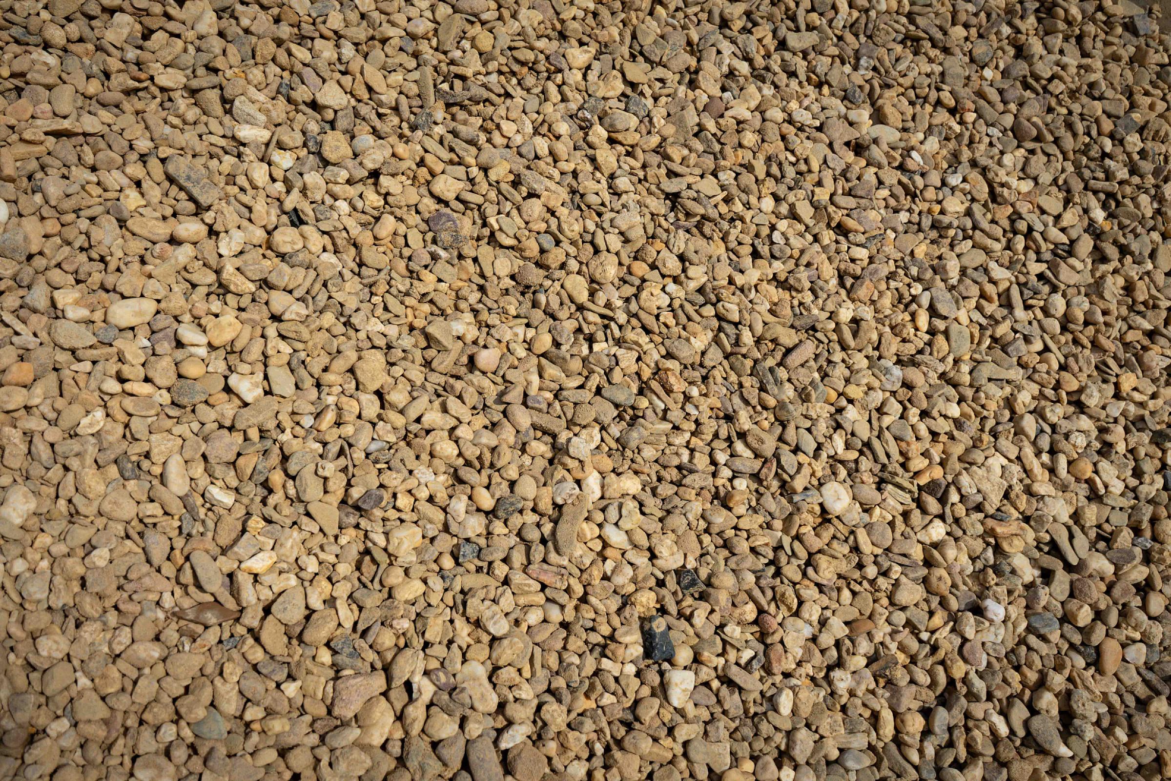 Rheinkies gewaschen, kleine Steine in verschiedenen Größen und Brauntönen, auf einem Haufen präsentiert.